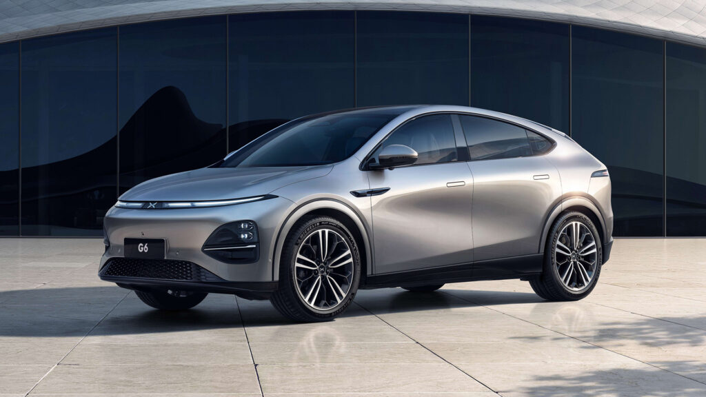 En silverfärgad SUV parkerad framför ett modernistiskt byggnad. (AI text)