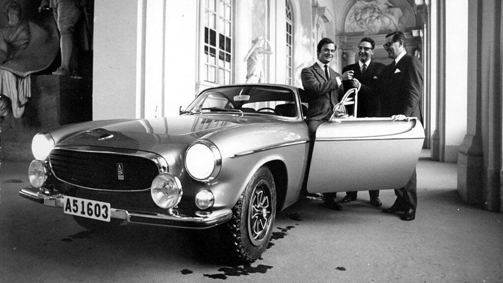 En grupp män står bredvid en bil. (AI text)