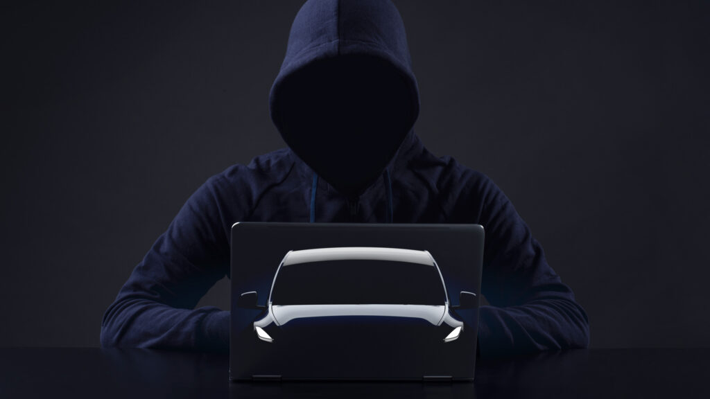 En man i en hoodie håller en lättask i framför en mörk bakgrund. (AI text)