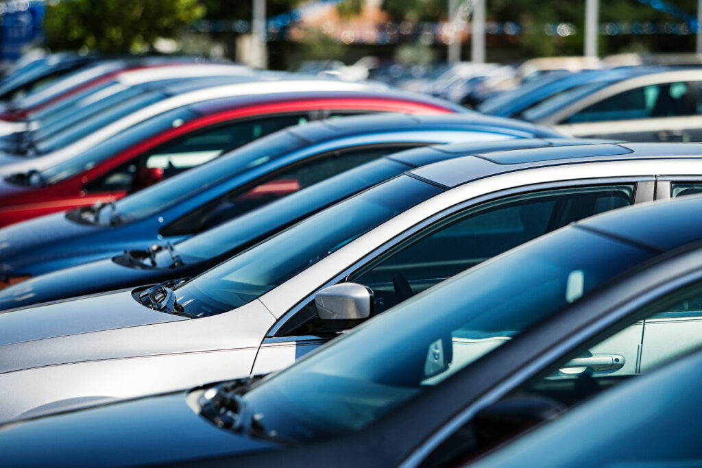 En rad bilar parkerade i en parkeringsplats. (AI text)