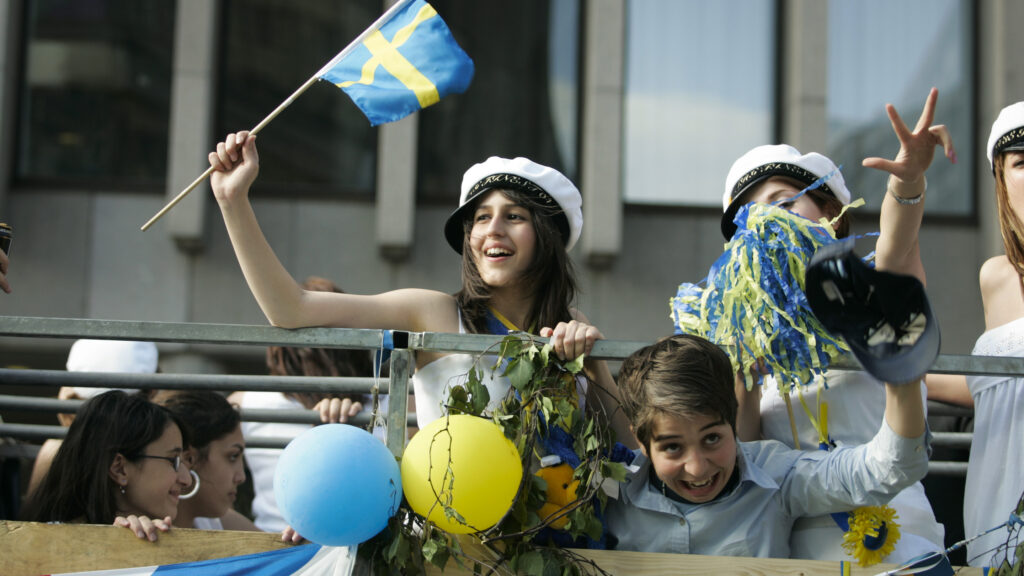 En grupp personer som vajar flaggor under en parad. (AI text)