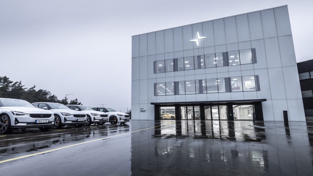 En grupp bilar parkerade framför ett byggnad. (AI text)