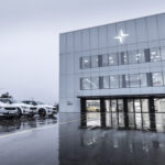 En grupp bilar parkerade framför ett byggnad. (AI text)