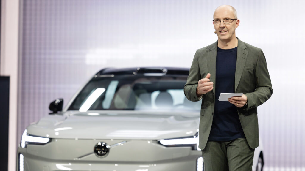 En man står bredvid en Volvo Ion elbil. (AI text)