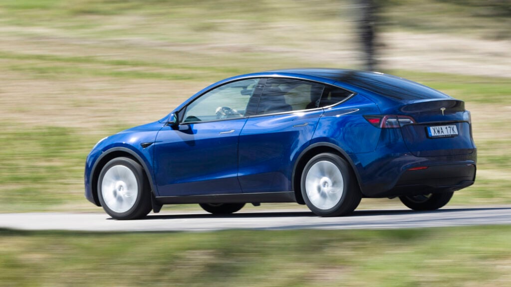 Tesla Model Y kör nedför en landsväg (AI text)