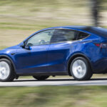 Tesla Model Y kör nedför en landsväg (AI text)