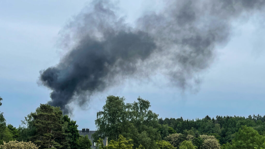 En svart rök stiger upp från en bil. (AI text)