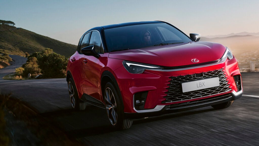 En röd Toyota CX-5 SUV kör nerför en bergsväg. (AI text)