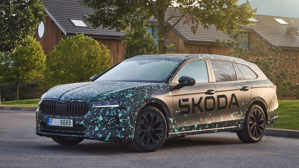 En Skoda EV står parkerad framför en husfasad. (AI text)