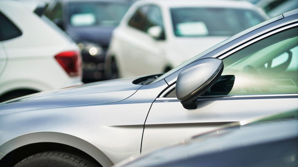 En grupp bilar parkerade i en parkeringsplats (AI text)