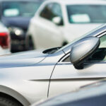 En grupp bilar parkerade i en parkeringsplats (AI text)