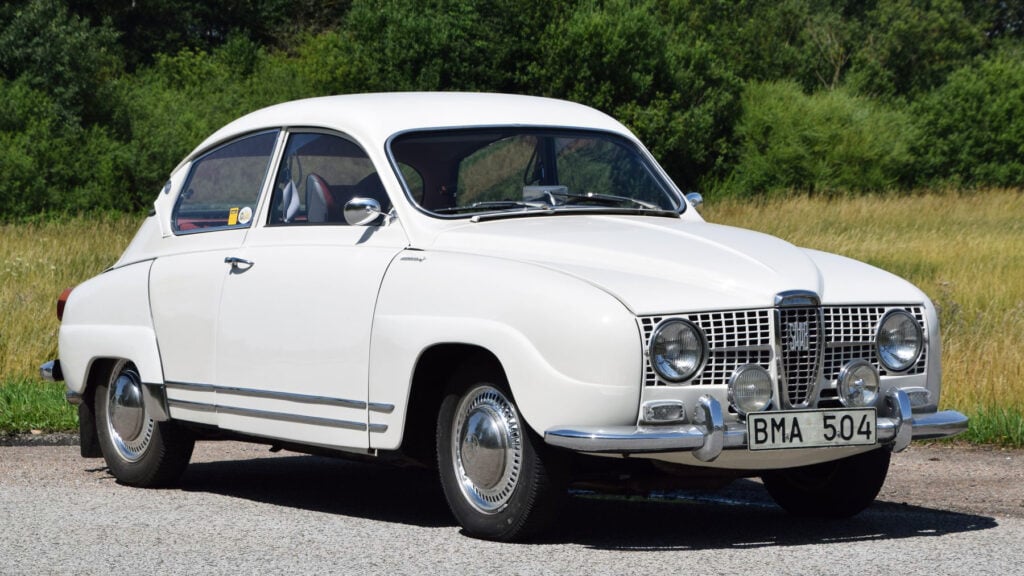 En vit bil parkerad i en åker. (AI text)