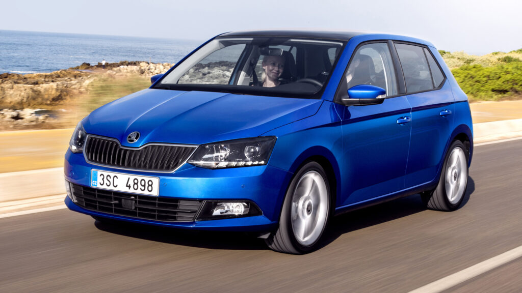 En blå Skoda Saxon kör nerför en väg. (AI text)