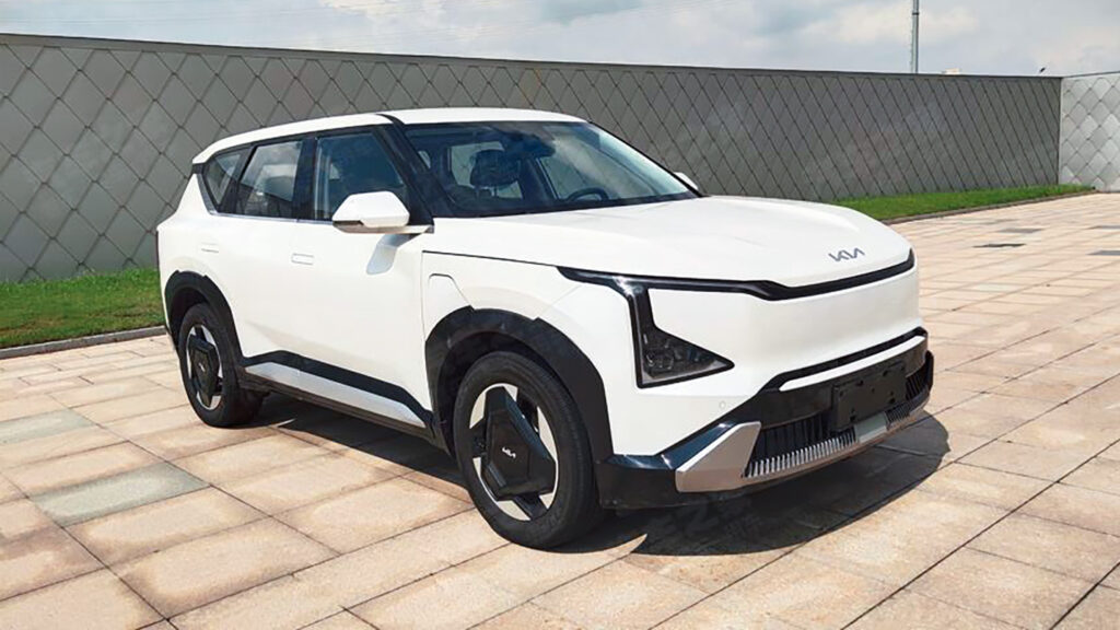 En vit SUV parkerad framför ett byggnad. (AI text)