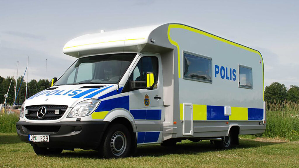 En polisbuss parkerad i ett fält. (AI text)