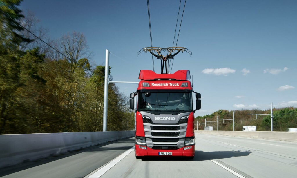 En lastbil kör längs en väg. (AI text)