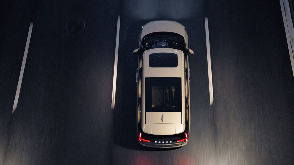 En bil kör fram på en högstadens väg på natten. (AI text)