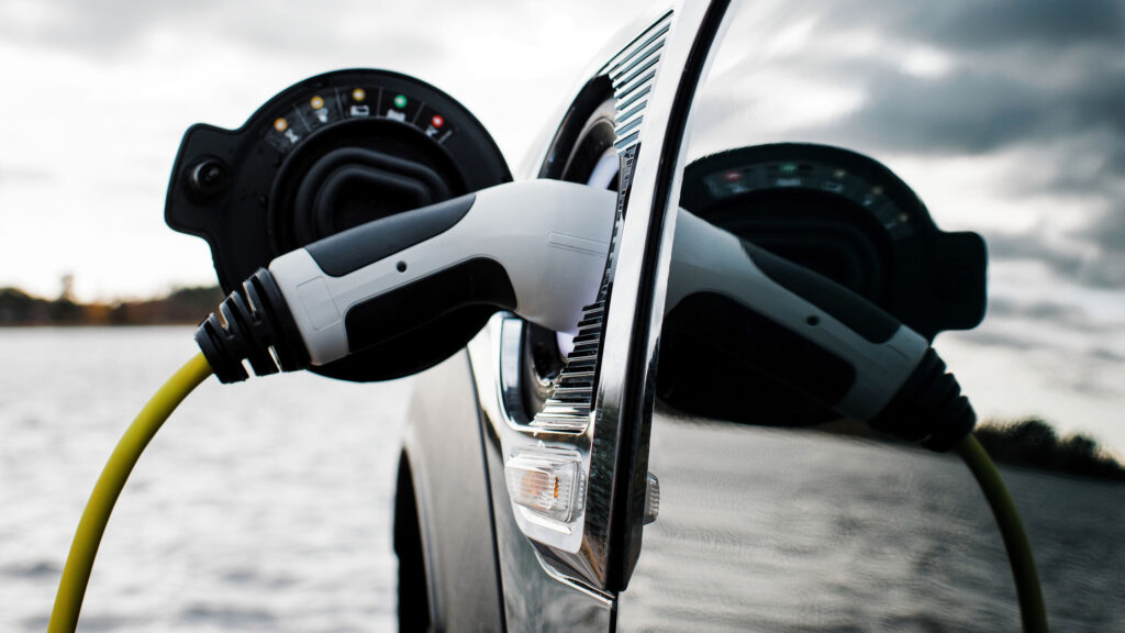 En bil är uppkopplad till en elladdare. (AI text)
