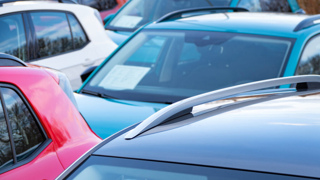 En grupp bilar parkerade i en parkeringsplats (AI text)