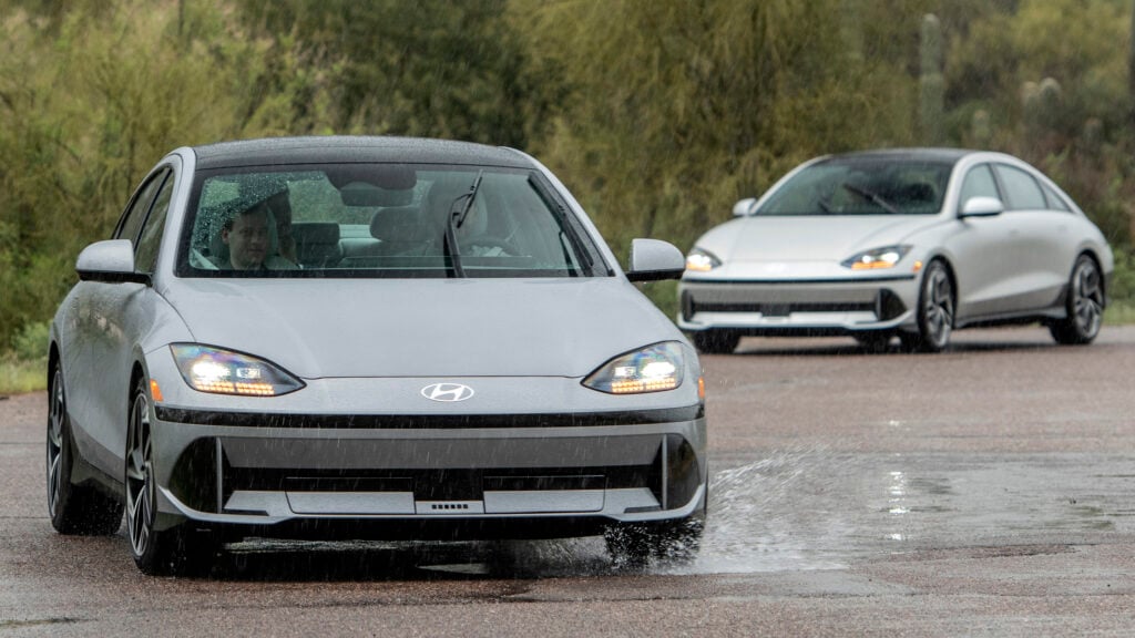 Bilar kör längs en väg. (AI text)