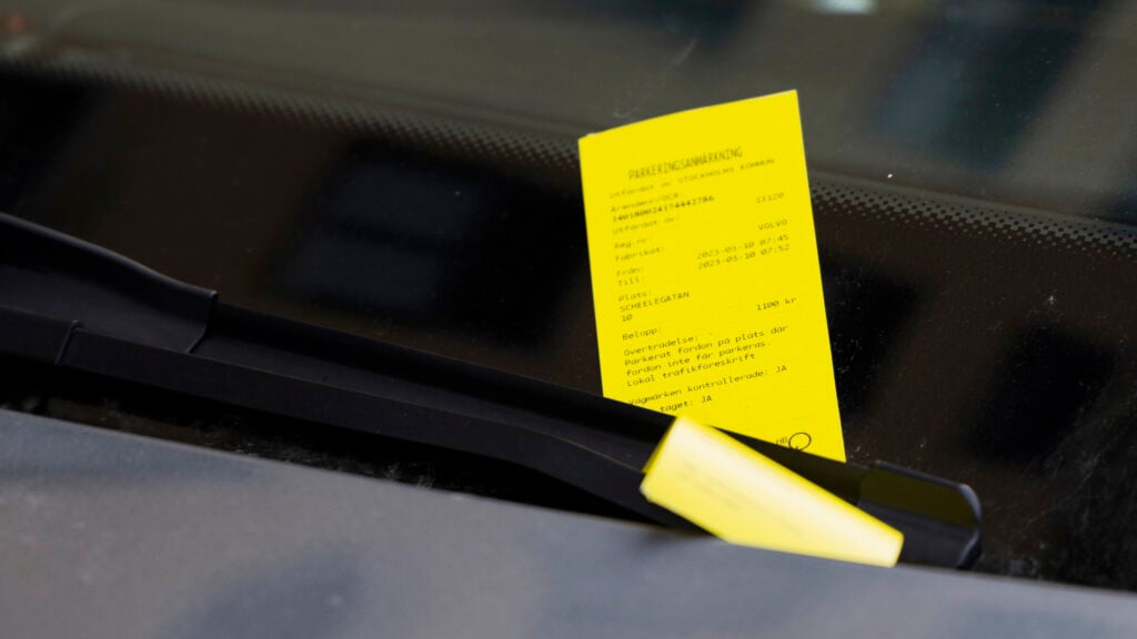 En bil med en gul parkeringskvitto på förarplatsen. (AI text)