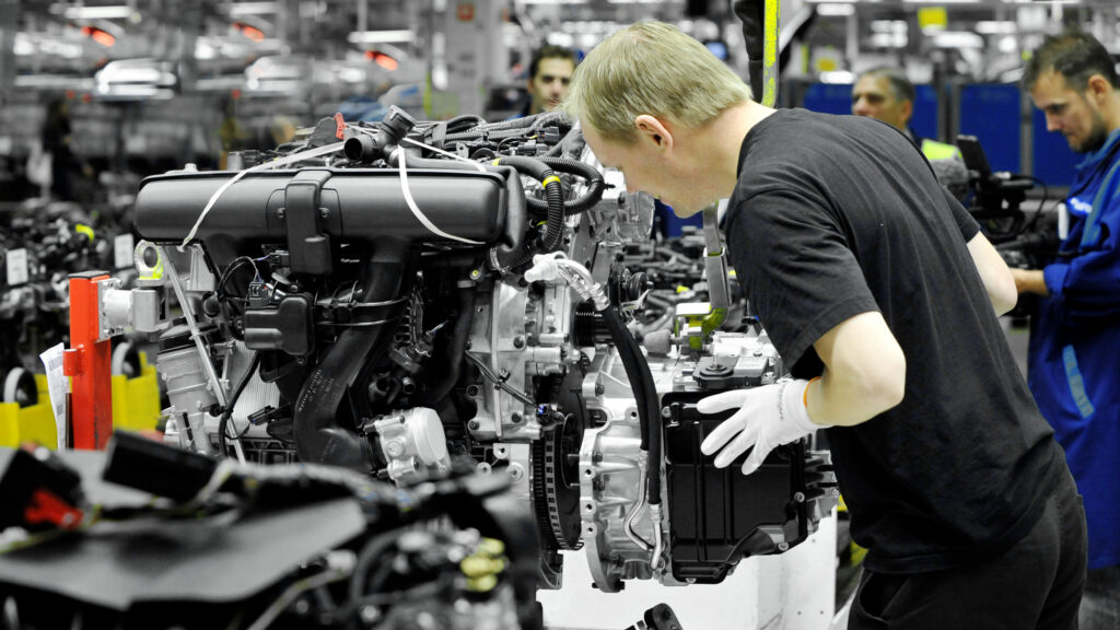 En biltillverkare monterar en motor i en fabrik. (AI text)