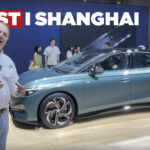 En man står bredvid en bil vid Samsung Shanghais bilmesse. (AI text)