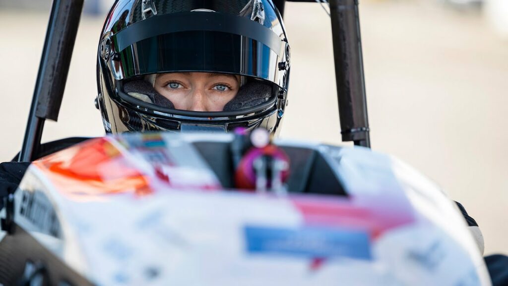 En kvinna i en racingbil. (AI text)
