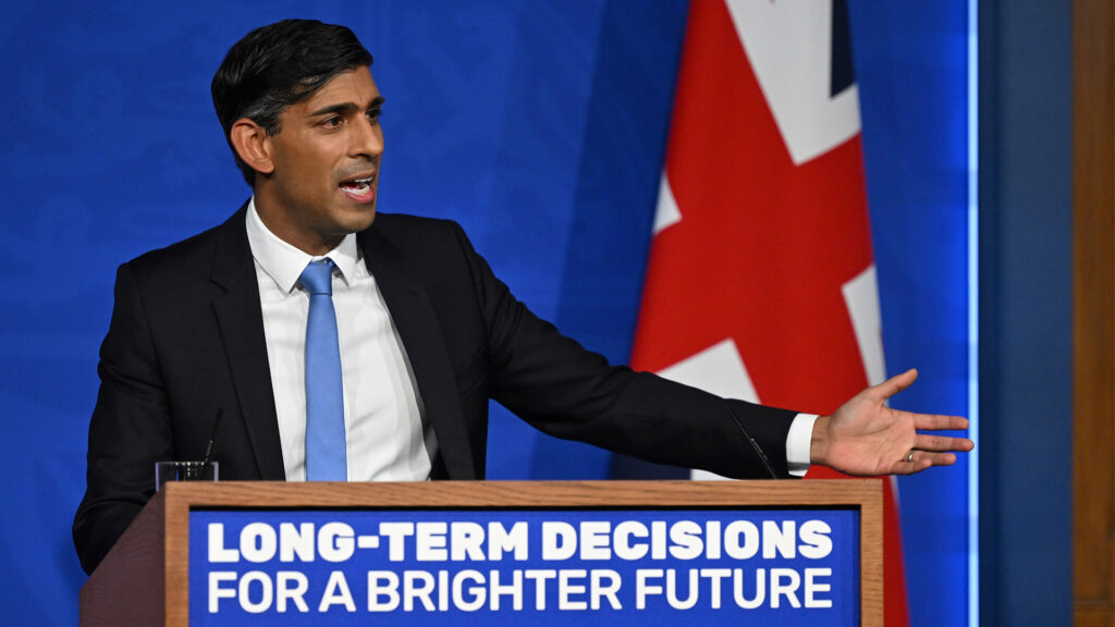 En man talar från ett podium framför en flagga. (AI text)