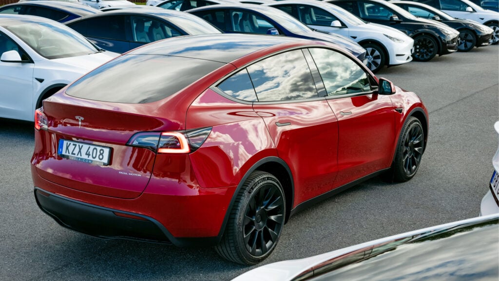 En grupp Tesla Model S bilar parkerade i en parkeringsplats. (AI text)