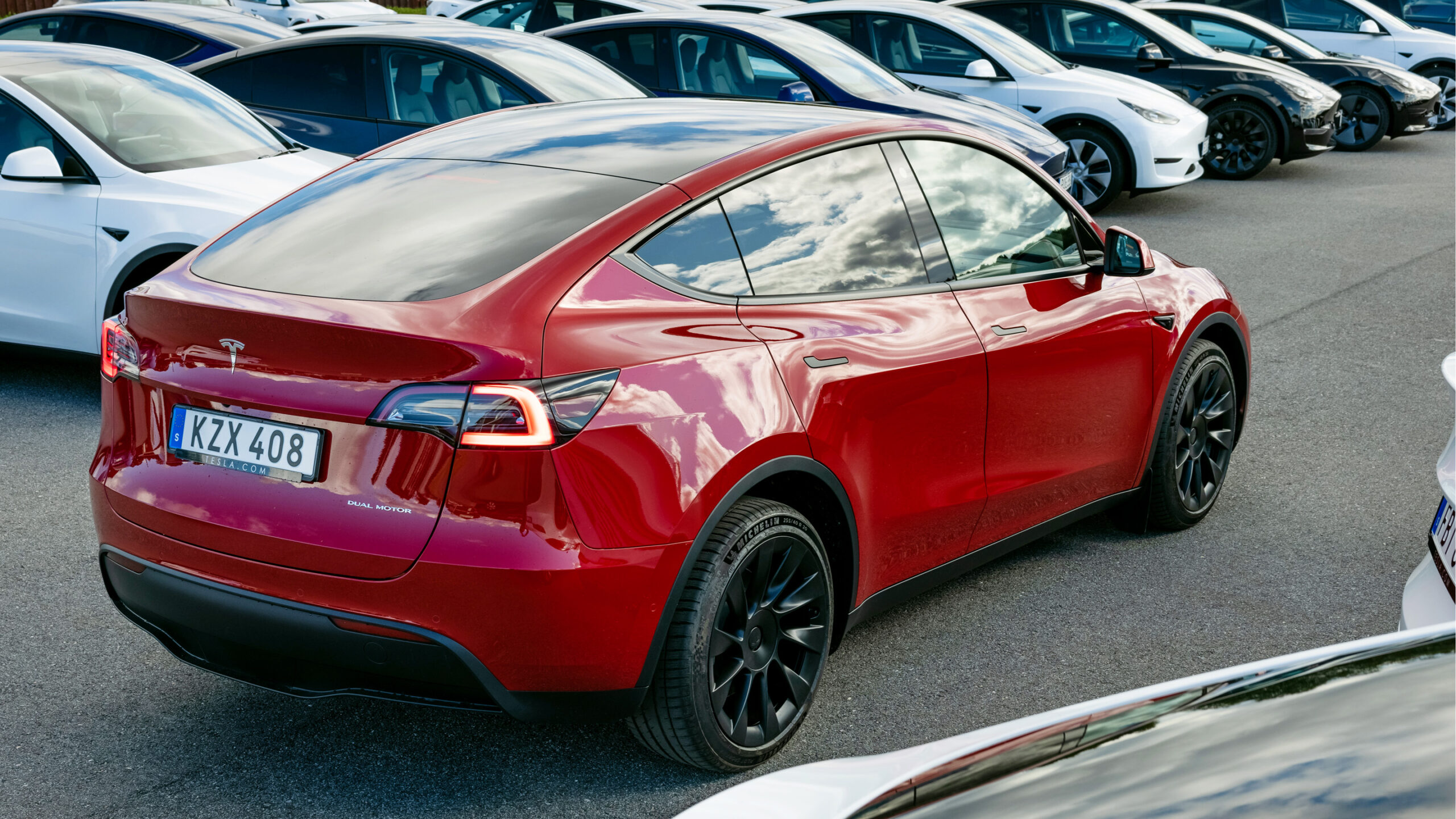 En grupp Tesla Model S bilar parkerade i en parkeringsplats. (AI text)