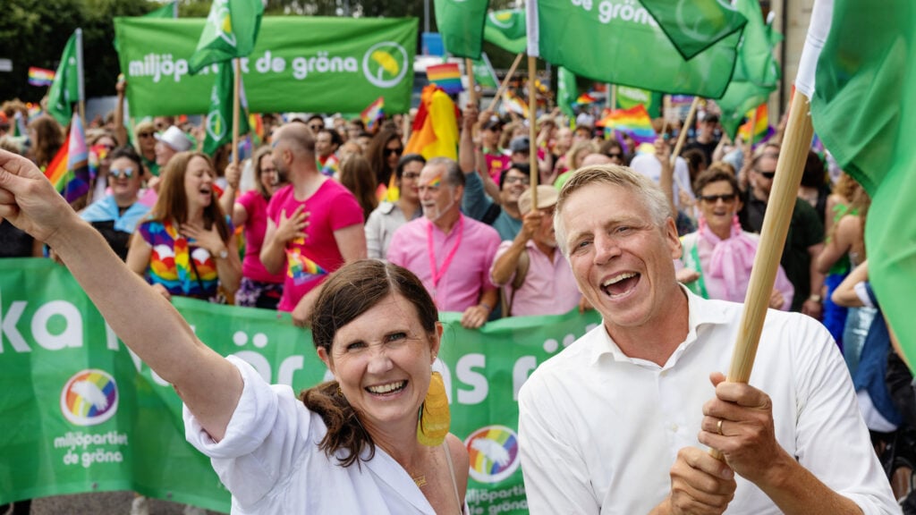 ett par personer som vajar flaggor under en parad (AI text)