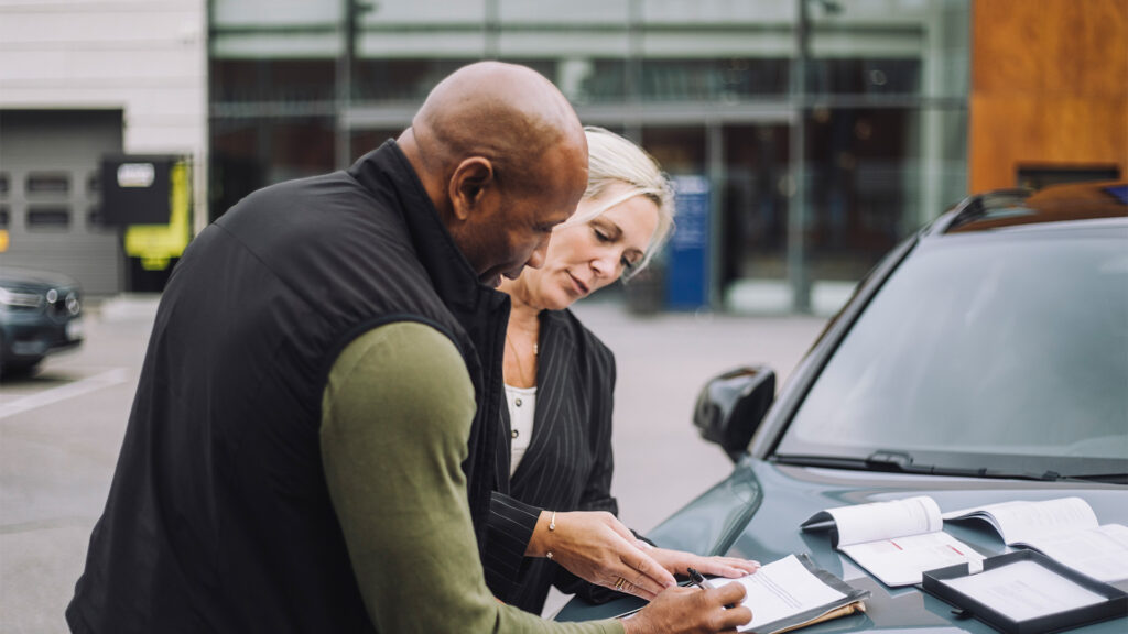 En man och en kvinna står bredvid en bil. (AI text)