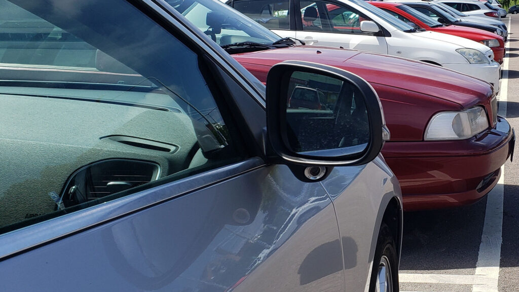 En rad bilar parkerade i en parkeringsplats. (AI text)