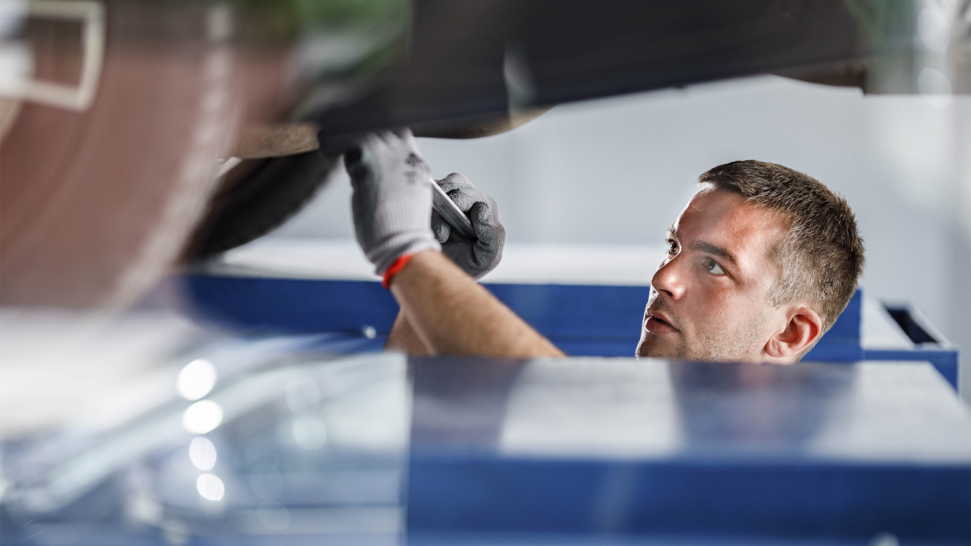 En mekaniker arbetar på en bil. (AI text)