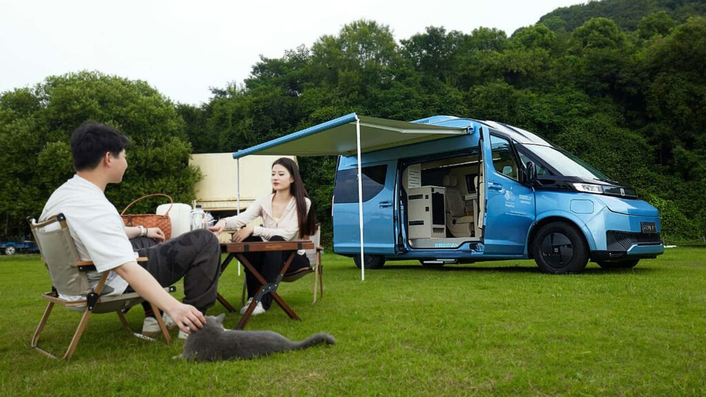 ett par sitter vid ett bord bredvid en campervan (AI text)