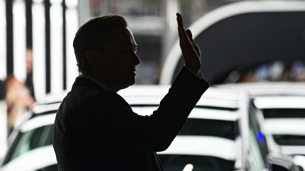 En man vinkar till publiken vid lanseringen av Audi A6. (AI text)