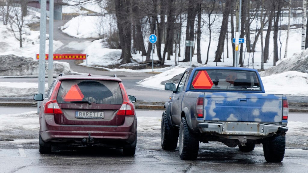 En bil är parkerad på en snöig gata. (AI text)
