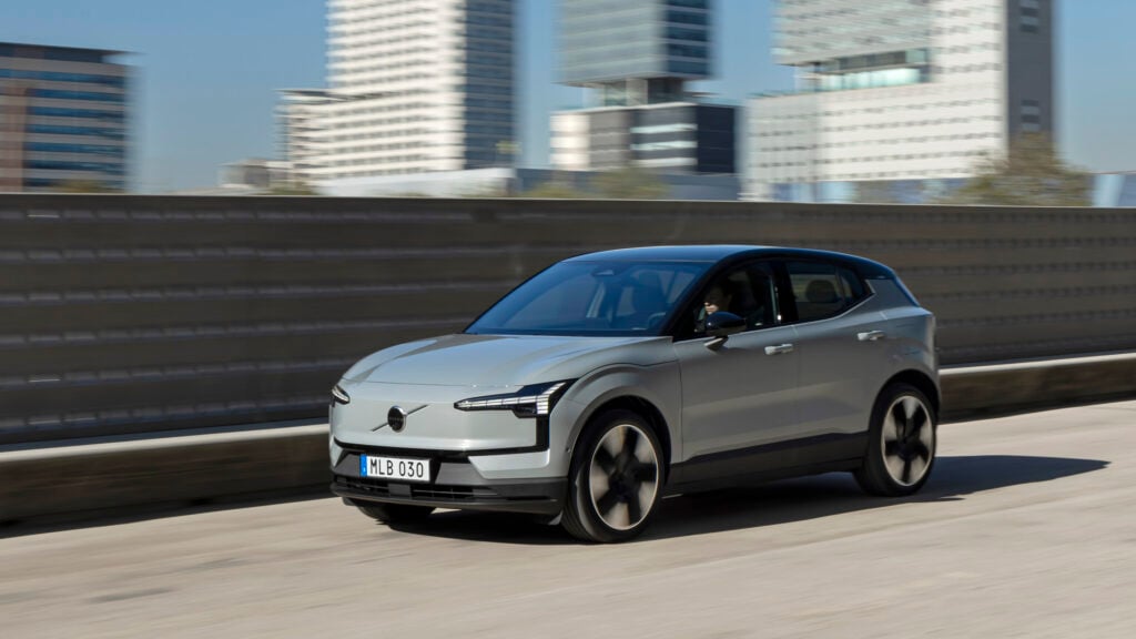 En bil kör nedför en stadsgata. (AI text)