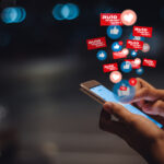 En man använder sin mobil för att titta på ikoner för sociala medier. (AI text)