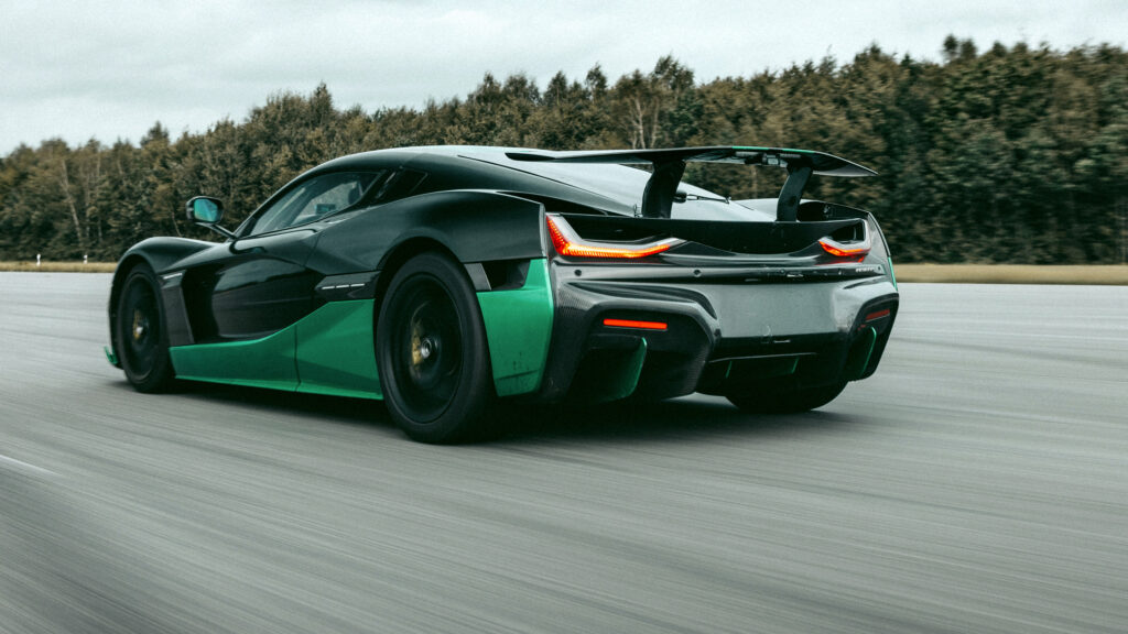 En grönglansad och svart McLaren P1 kör på en bana. (AI text)