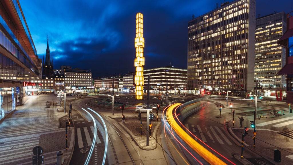 En stad vid nattid med en bil i bakgrunden. (AI text)