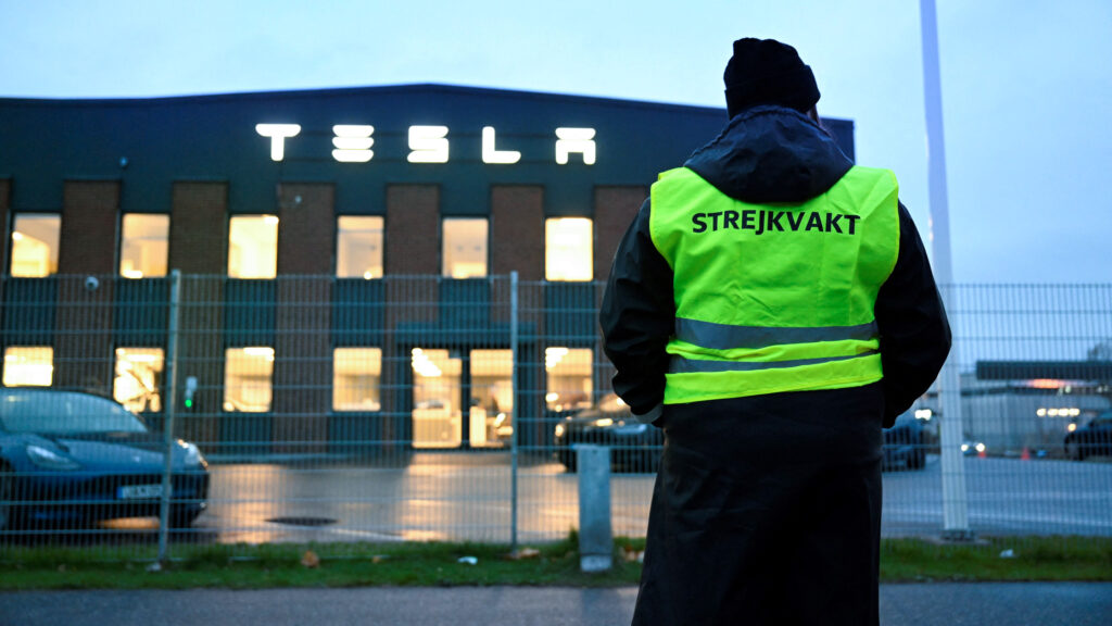 En arbetare står framför Teslas fabrik i Sverige. (AI text)