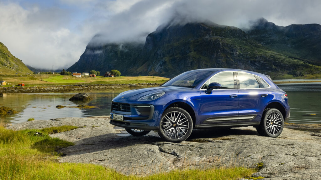 En Porsche Macan parkerad på en klippa i bergen. (AI text)