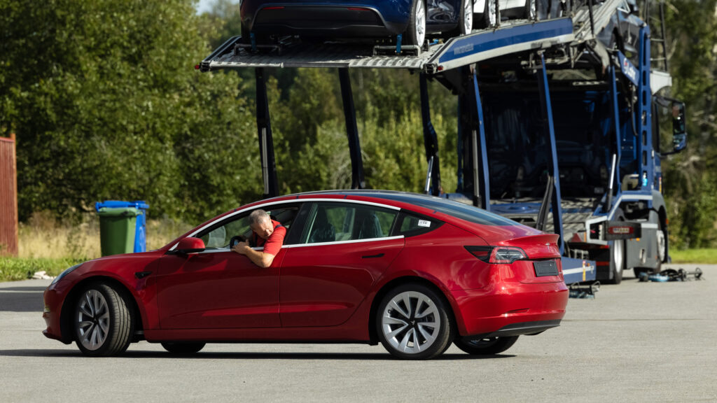 En Tesla Model 3 parkerad på en lastbil. (AI text)