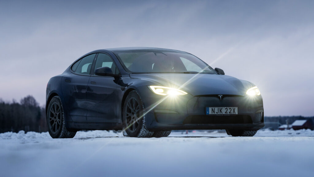 En Tesla Model S kör på en snöig väg. (AI text)
