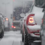 En bil kör nerför en snöig väg. (AI text)