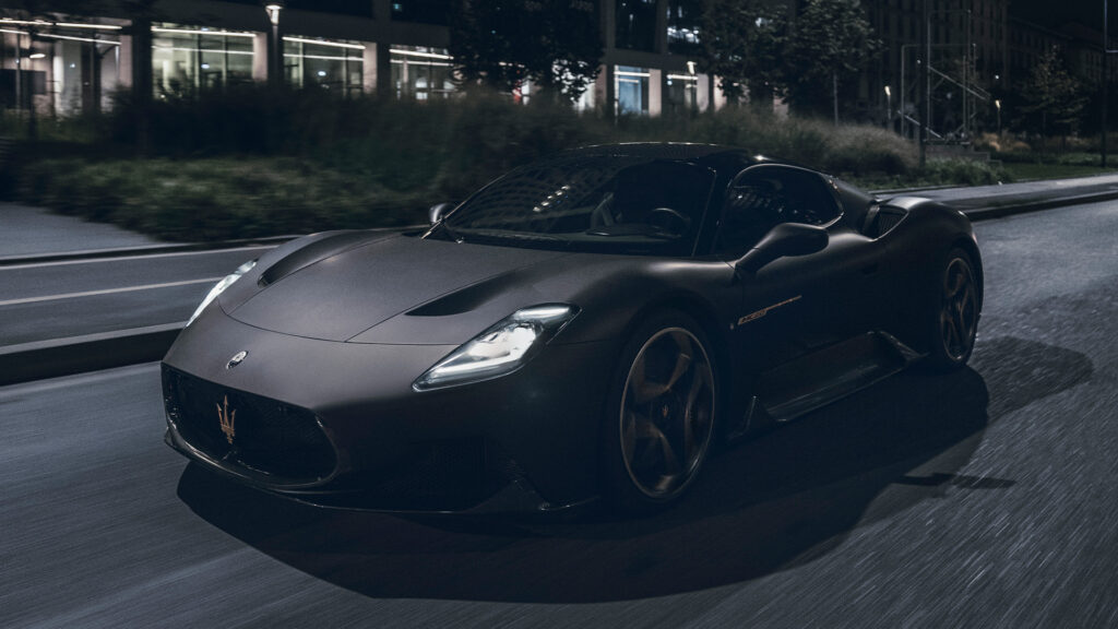 En svart sportbil kör genom en stadsgata på natten. (AI text)