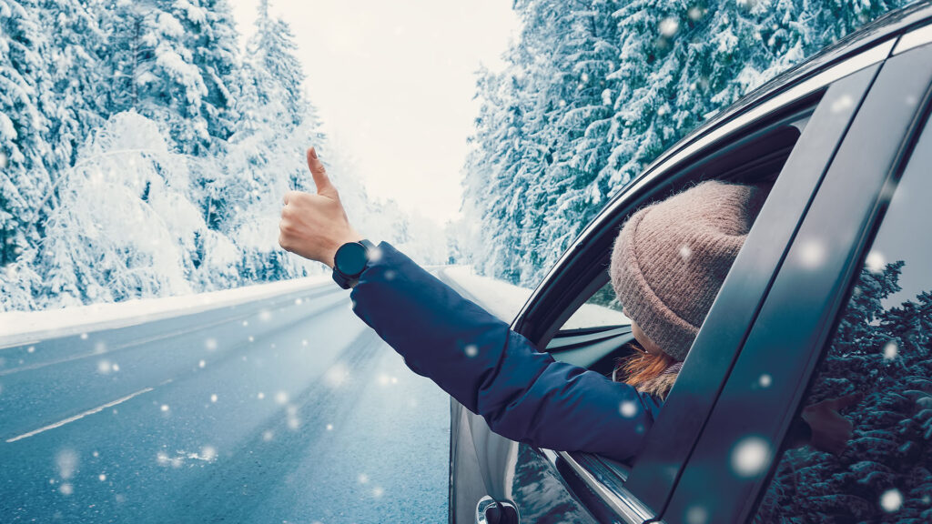 En kvinna kör en bil i snön. (AI text)