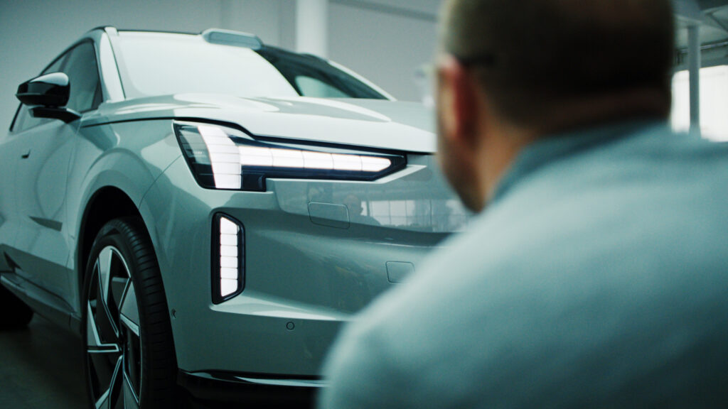 En man tittar på en bil. (AI text)